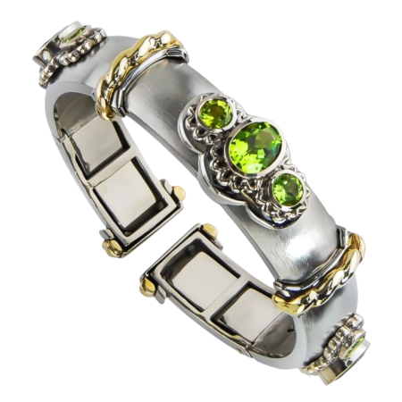 40417A Wide Peridot Callista Bangle Designed & Handmade by Kaufmann de Suisse in 18kt White Gold featuring 3 Oval Peridots weighing a total of 5.88cts and 6 Round Peridots weighing a totla of 4.00
